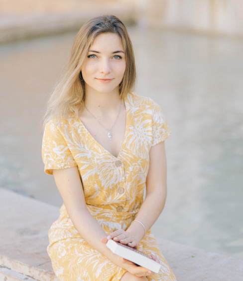 Femme assise en robe jaune près de l’eau, évoquant la douceur, la lumière et la confiance retrouvée.